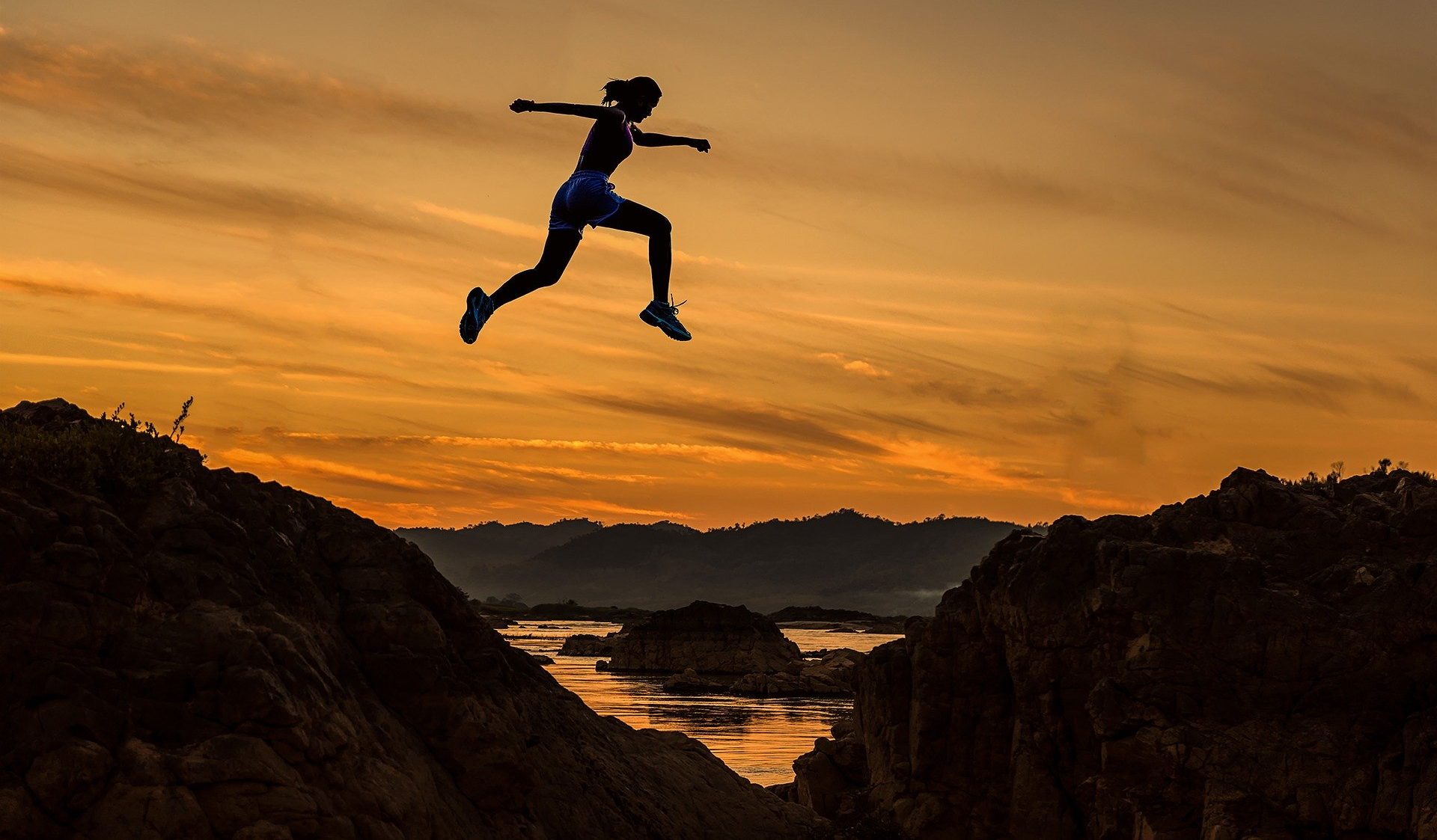 Girl jumping across mountains
